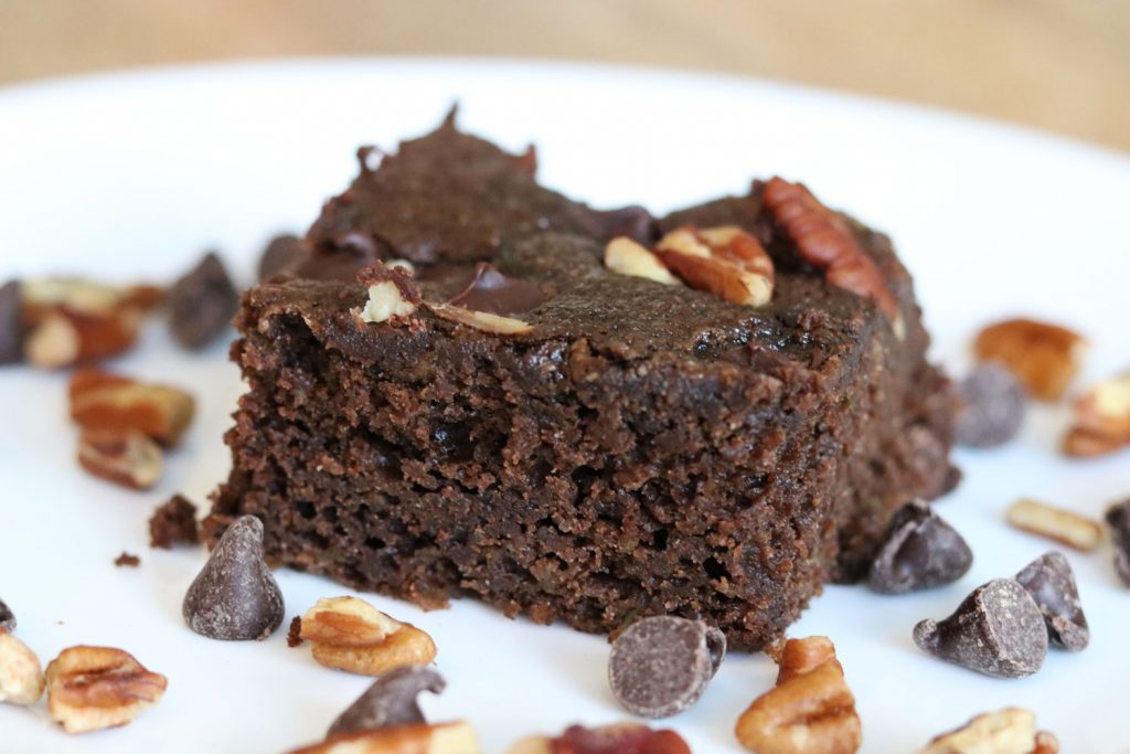 chocolate zucchini cake with chocolate chips and nuts on a plate